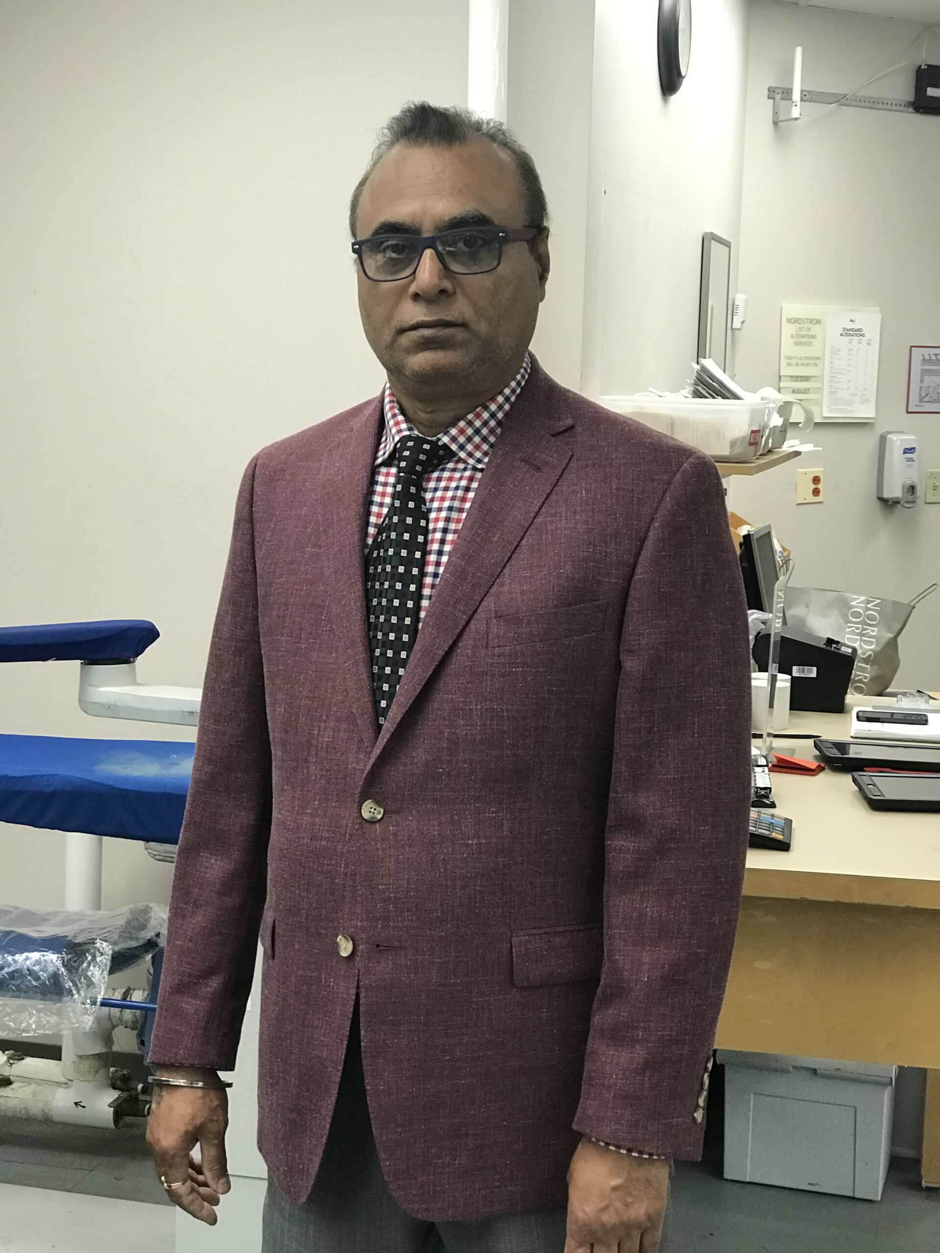 Customer receiving custom-tailored clothing at Anhad Tailor shop